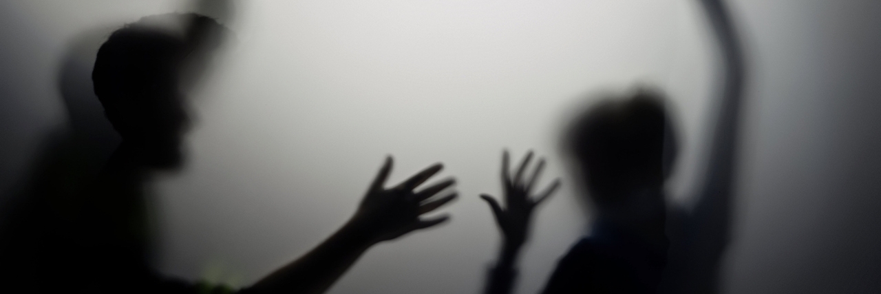 Silhouette of man and woman with raised hands