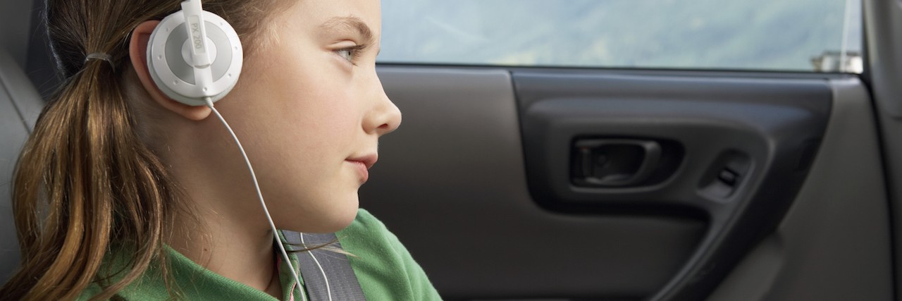 Explaining 'Normal' to My Daughter With Sensory Processing Disorder Girl (6-8 years) in car wearing headphones, close-up, side view