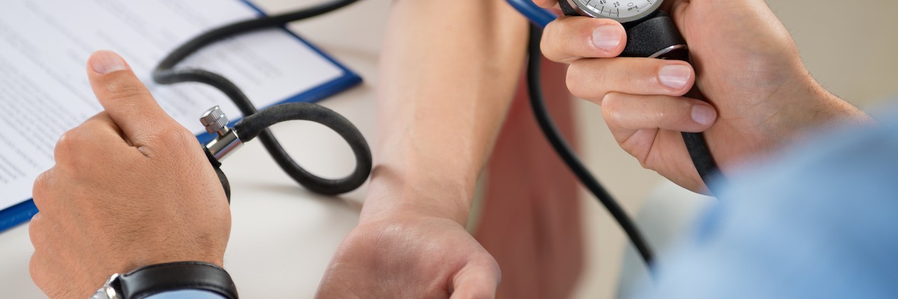 When a Doctor Finally Told Me What I Needed to Hear About Living With Hypochondria Close Up Of A Doctor Checking Blood Pressure Of A Patient