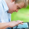 Close up portrait of man outdoors with digital tablet.