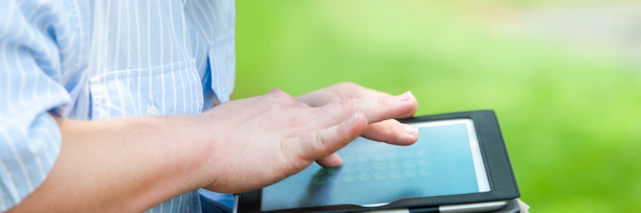 Down Syndrome Memes, Tweets, Jokes and Insults: What Should We Do? Close up portrait of man outdoors with digital tablet.