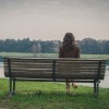 Young woman sitting on a bench in a city park