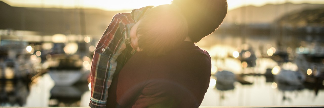 Mom of Kids With Autism Thanks Man at Waterfront After Meltdowns Young boy is laying his head on mom's shoulder.