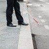 A blind person crosses the street.