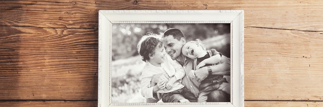 Tips for Getting Through a Fatherless Father’s Day Picture frame with family photo laid on a wooden backround.