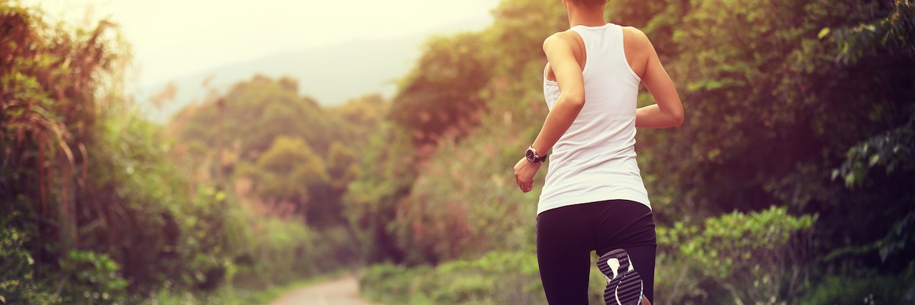 Running as a Way to Manage OCD and Eating Disorder young fitness woman runner running at forest trail