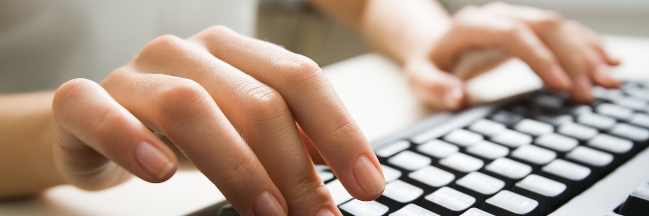 Close-up of hands typing on a keyboard