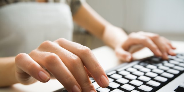 Close-up of hands typing on a keyboard