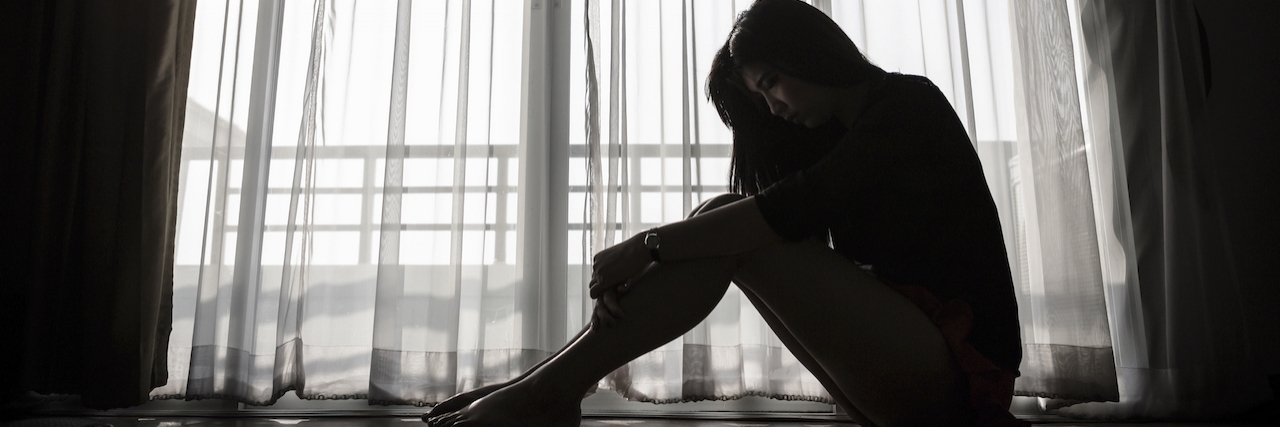 To the People Who Believe Happiness Is a Choice sad woman sitting alone looking out a window
