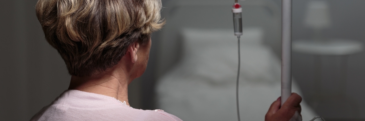 My Disease Affects One in a Million – This Is What It’s Like Trying to Get Treated Sick woman with drip walking in hospital