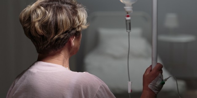 My Disease Affects One in a Million – This Is What It’s Like Trying to Get Treated Sick woman with drip walking in hospital