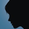 Silhouette of a woman's head against a blue background