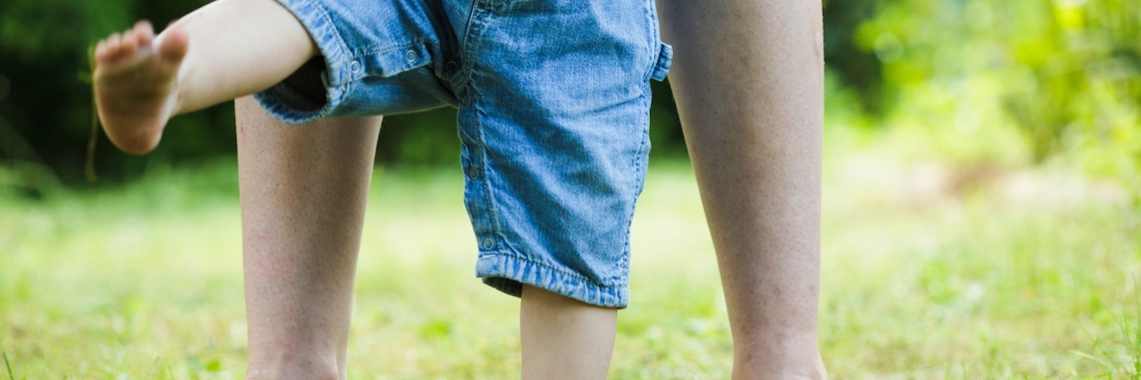 Advice for New Moms With Chronic Illnesses First steps of baby from mother on grass