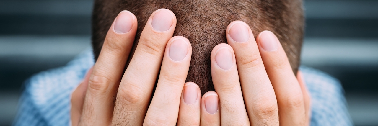 Married to PTSD: How to Cope Closeup portrait of despaired young man covering his face with hands.