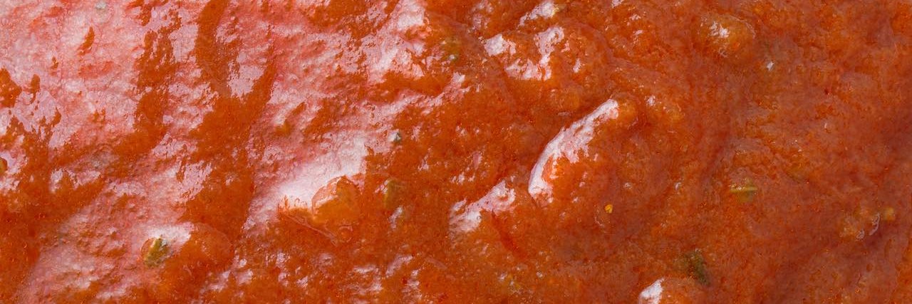 Father's Day Tribute: Dad Pours Marinara Sauce Instead of Formula A very close view of marinara sauce illuminated with window light.