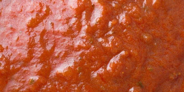 A very close view of marinara sauce illuminated with window light.