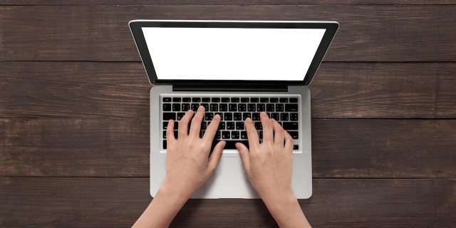 How to Research Your Child's Medical Condition Like a Pro Hands using with laptop on the wooden table.
