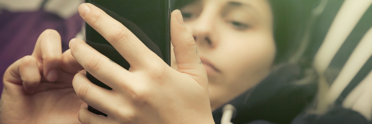 How Texting Helps Someone With Depression Communicate a woman on her phone on bed