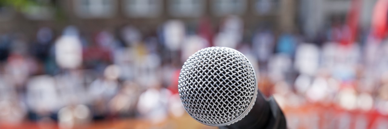 To the Political Leaders Who Address Mental Illness Without Care Microphone in focus against unrecognizable crowd