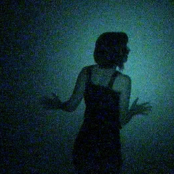 Woman from behind which looks lost in the darkness blue.