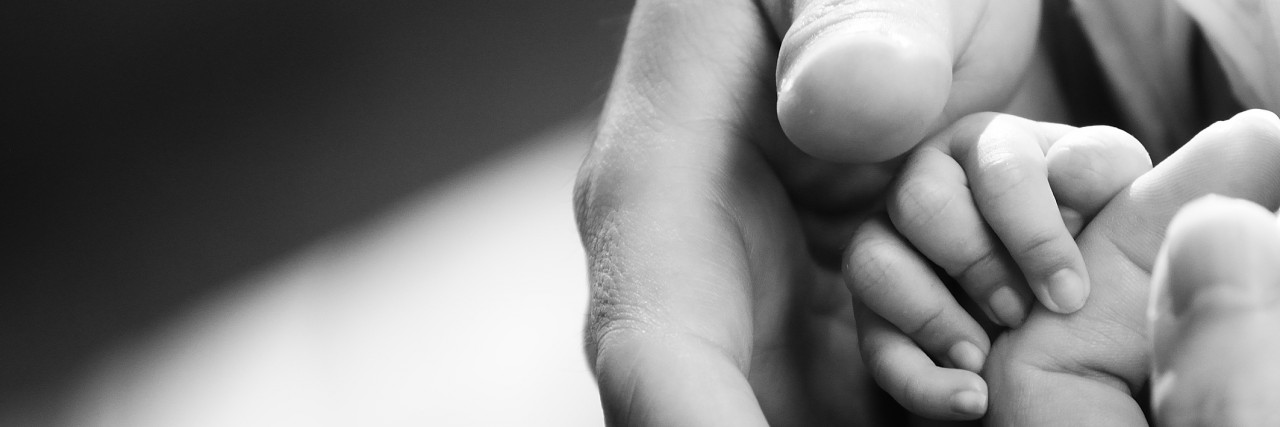 Mom Writes to Doctor Who Told Her Not to Get Attached to Her Baby Baby hand gently holding adult finger.