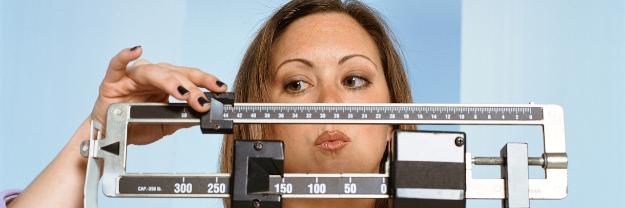 Experiencing Weight Gain When Taking Medication for Bipolar Disorder Woman on scale