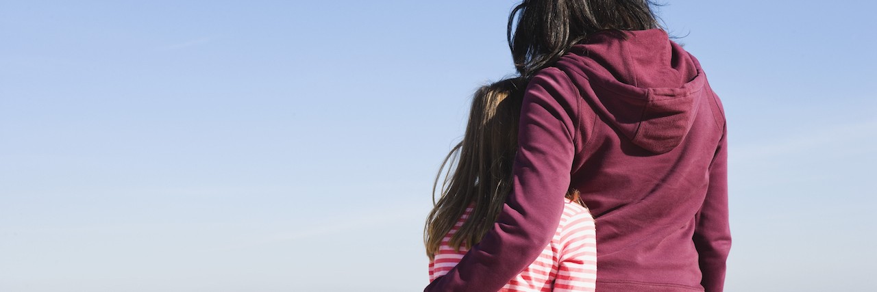 How to Talk to Kids About Postural Orthostatic Tachycardia Syndrome Mother and daughter on a beach with arms around each other