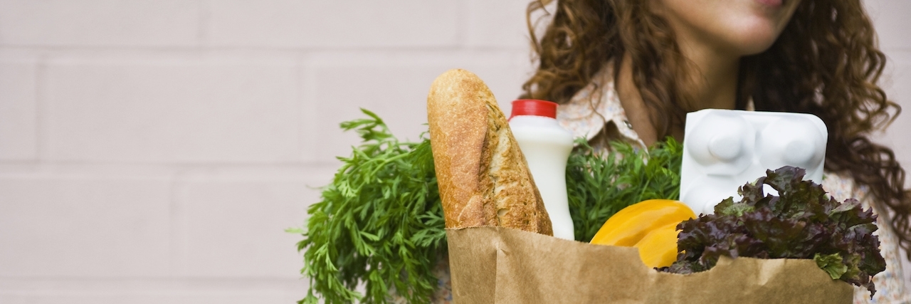 Girl With Ehlers-Danlos Syndrome Responds to Customer's 'Weak' Comment Woman carrying a bag of groceries
