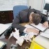 Businessman face-down on messy desk