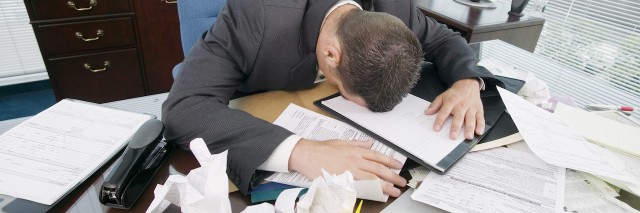 Businessman face-down on messy desk