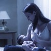 a young mother holds her newborn baby at night