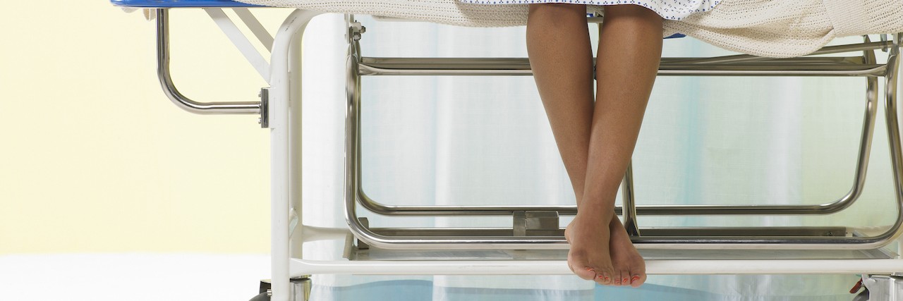 What to Tell a New Doctor as an Undiagnosed Patient Female patient sitting on gurney in hospital gown