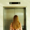 back of a blonde woman waiting for the elevator