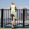 Woman leaning on railing in New York City looking at the skyline
