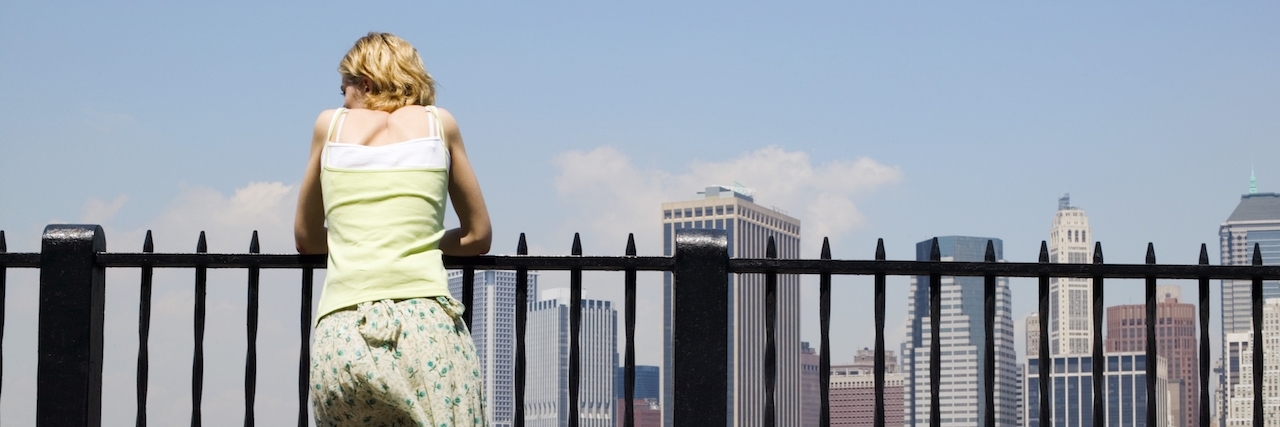 Lessons From the People Who Hurt You in Depression Woman leaning on railing in New York City looking at the skyline