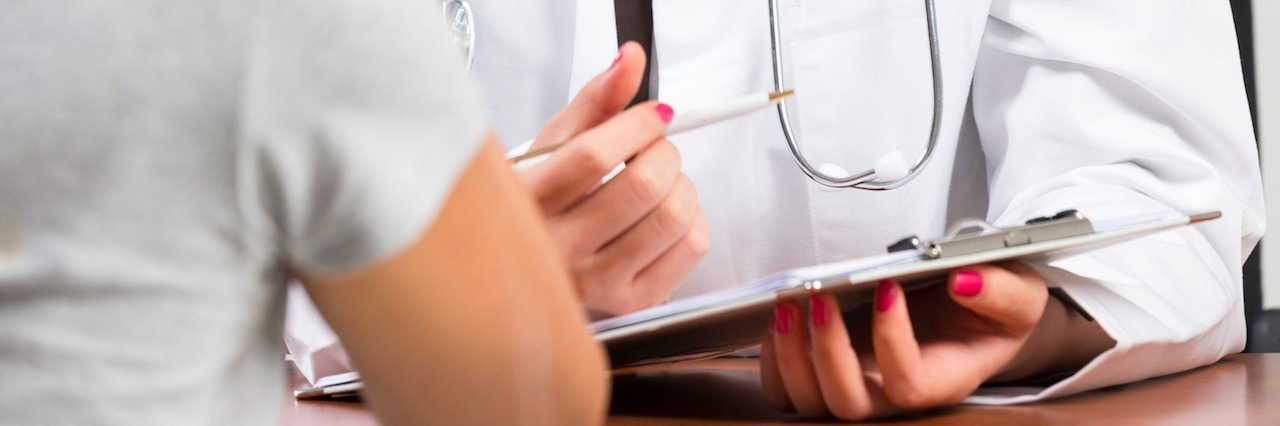 Woman With Hemiplegic Migraines Finds Doctor Who Understands Her Pain doctor talking with female patient in doctors office.