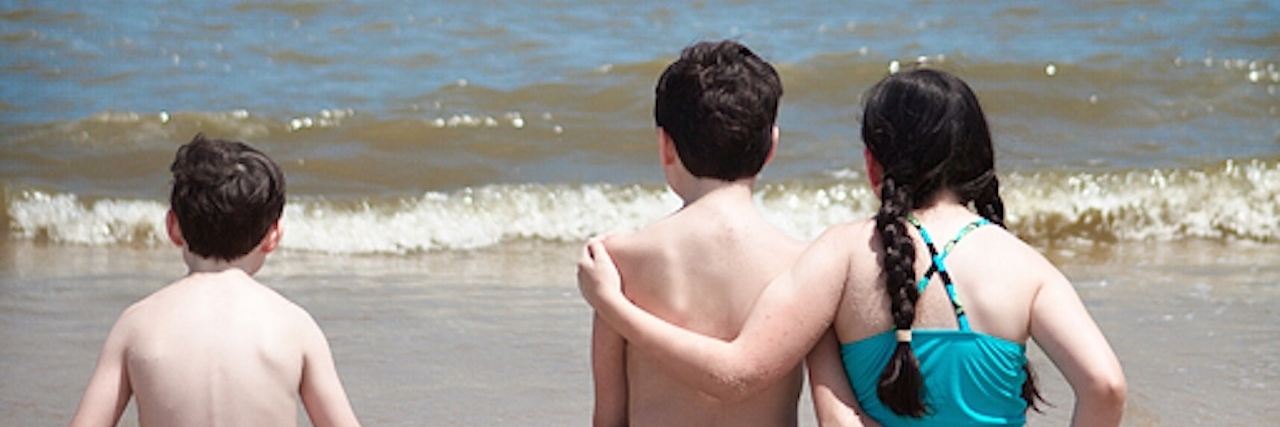 Lauren's children arm in arm on the beach