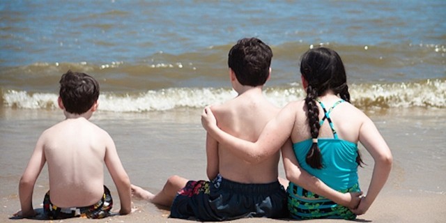 Lauren's children arm in arm on the beach