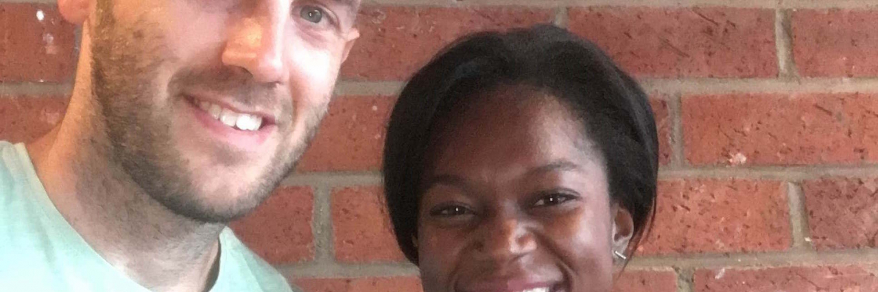 What It's Like Having a Girlfriend With Endometriosis Couple (white man and Black woman) smiling in front of brick wall background