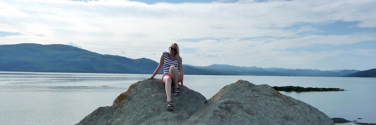 Letter to My Healthy Self After I Got Sick woman sitting on rock by water