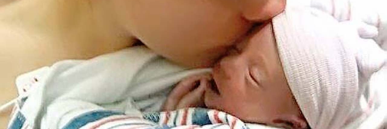 Staring at Special Needs Children After Losing a Child mom kissing newborn