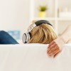 woman sitting on couch with headphones on