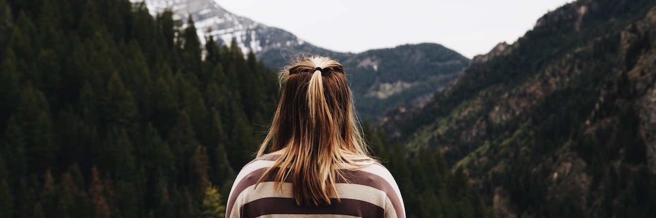 Living With Hashimoto's Thyroiditis and Celiac Disease Woman with her back to the camera, facing the mountains