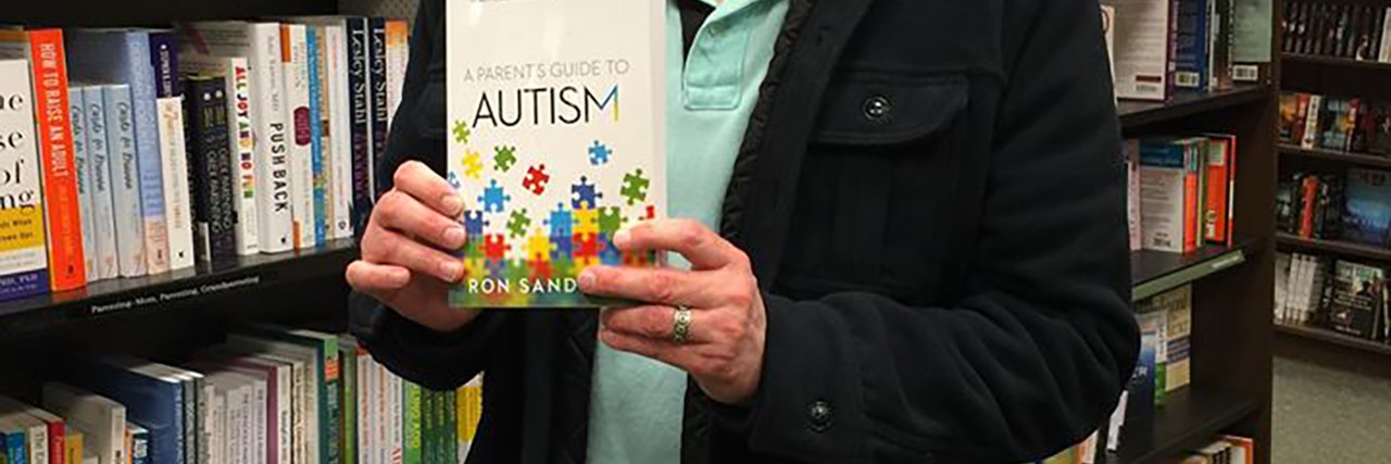 Ron with his published book about autism.