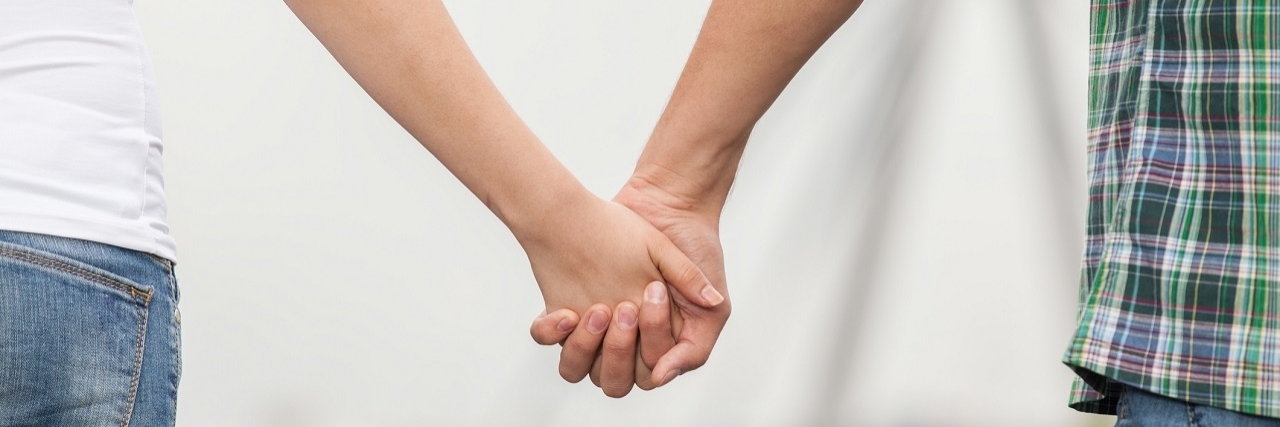 Dating Someone With Depression and Having Depression Couple holding hands while walking along quay