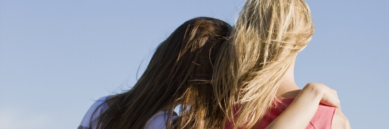 Benefits of Online Social Media Support Groups for Chronic Illness Two young women looking across the city, rear view