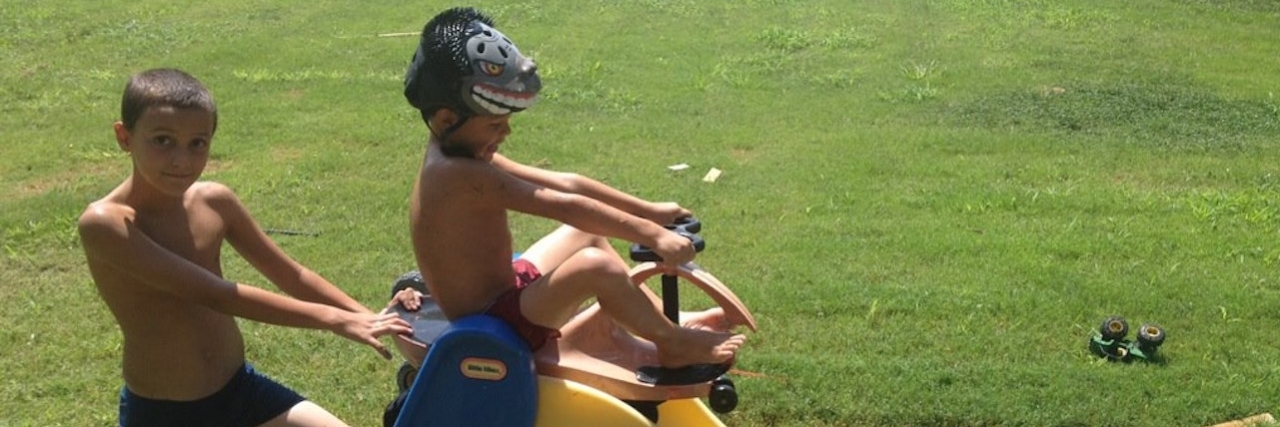 My Parenting Fails brothers about to go down a slide on a scooter