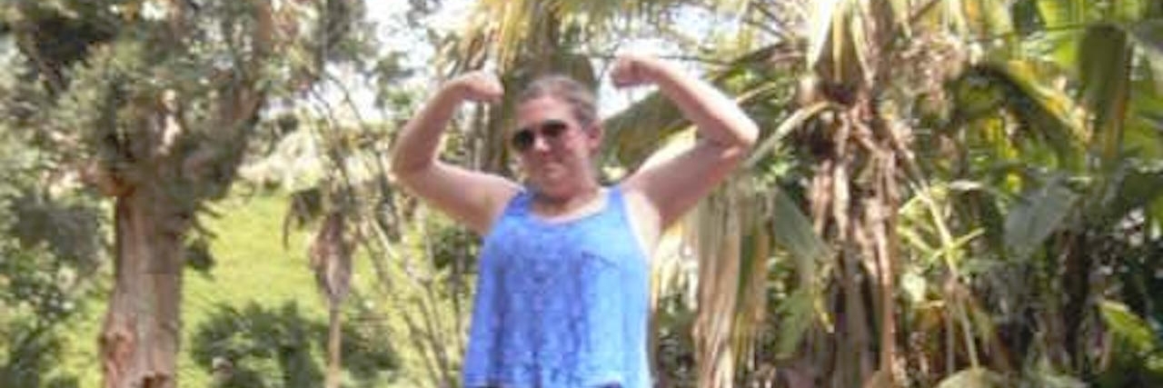 Psychiatrist's Advice About My Struggle With Bipolar Disorder woman flexing her muscles standing on a rock