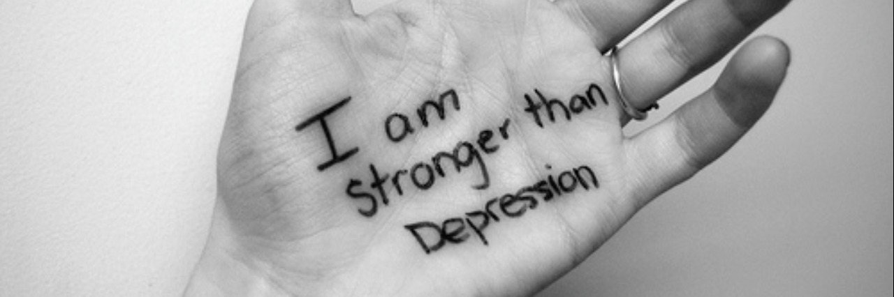 A hand with the words "I am stronger than depression," on the palm.