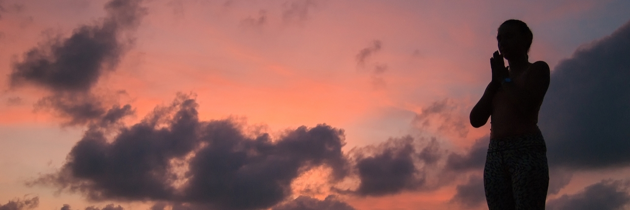 What Helps People With Depression Remain Hopeful Woman stands near seashore in front of colorful sunset